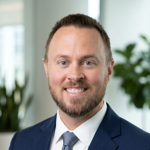 Cameron Magnuson, agent in charge at Magnuson Insurance, in a navy suit and blue tie.
